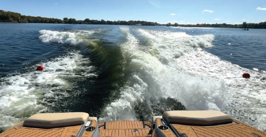 Photo: Wakeboat in semi-displacement mode (Surf Mode) being driven over an acoustics-based sensor that measured water pressures and velocities through the water column and the lake bottom.